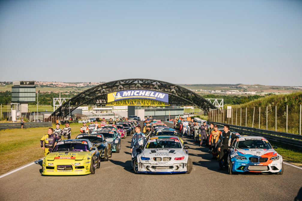 Drivers and drift cars lined up on the grid before the competition